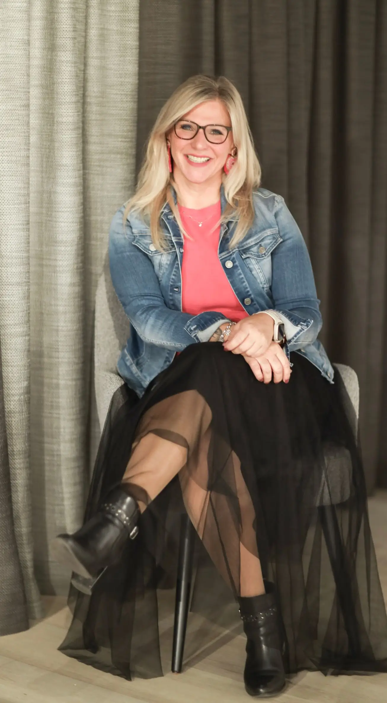 Profilbild Heike Schönbacher in Jeansjacke und schwarzem Rock - sitzend