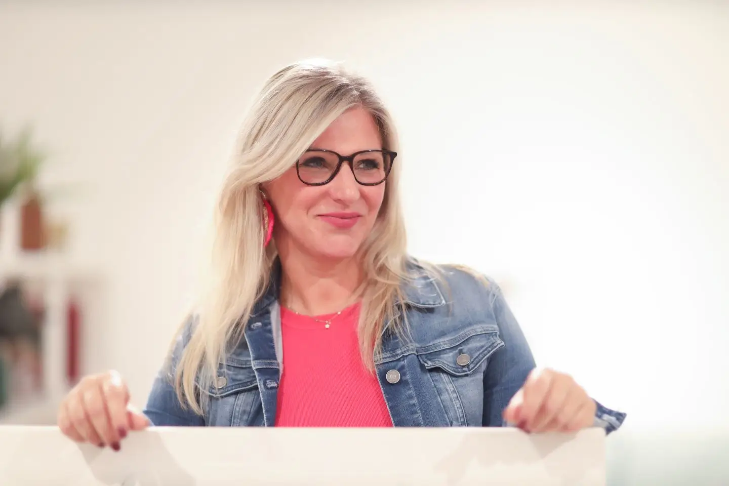 Heike Schönbacher im Profil hinter einem halbhohen Board, die Hände aufgestützt