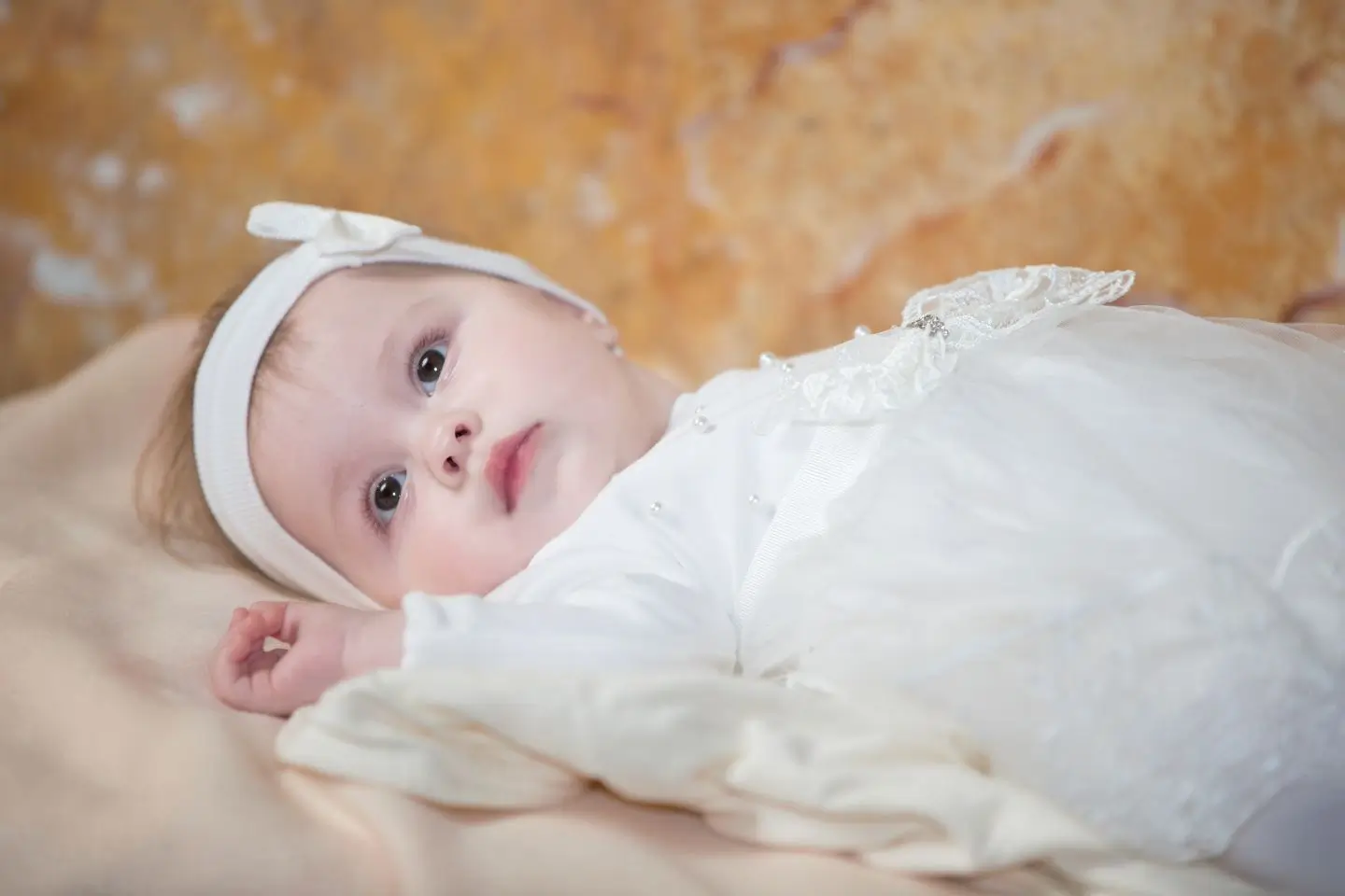 Baby im weißen Taufkleid bei freier Taufe in der Steiermark