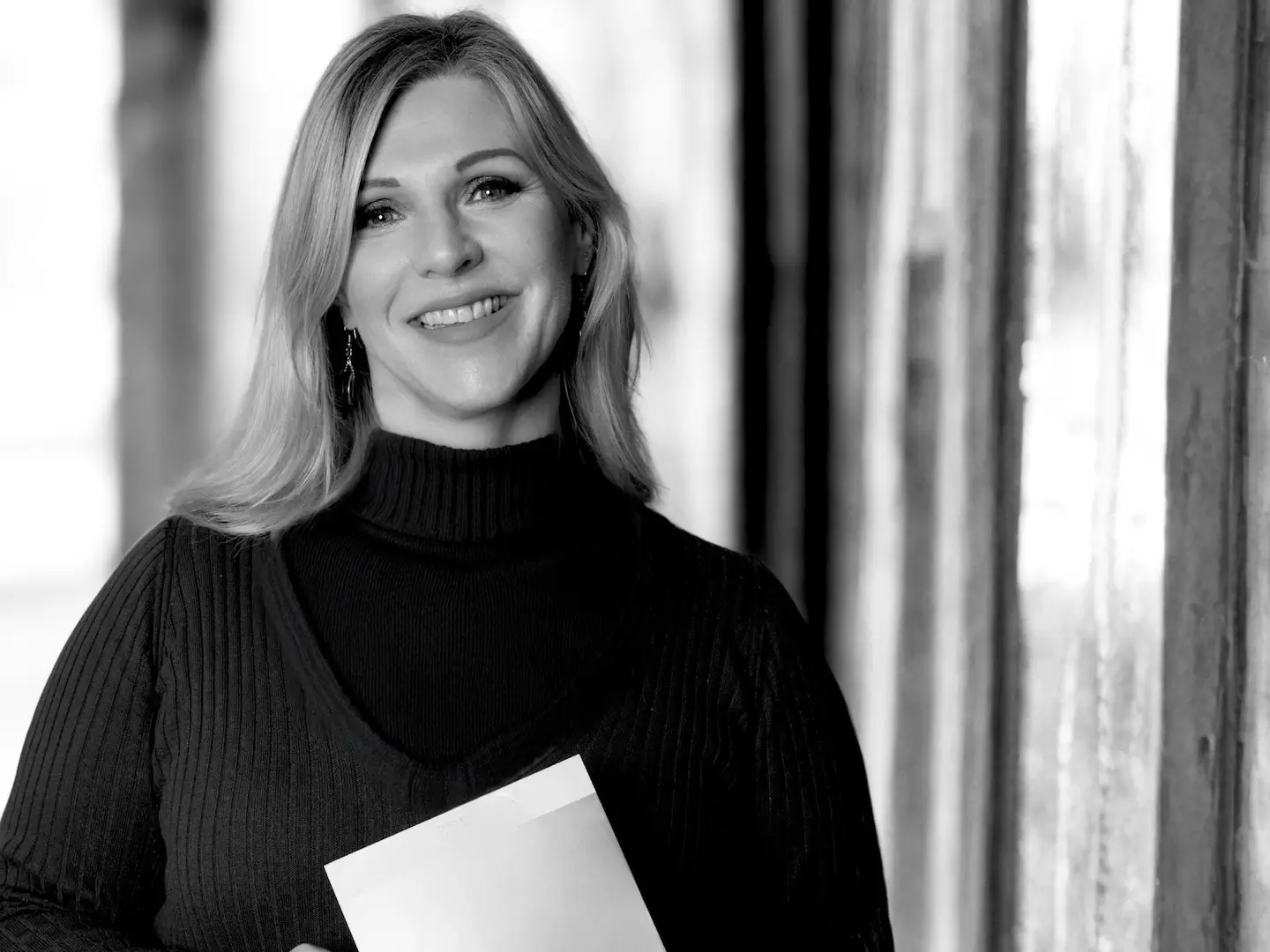 Heike Schönbacher, Trauerrednerin Graz, Profilbild mit Unterlagen in den Händen, schwarz-weiß