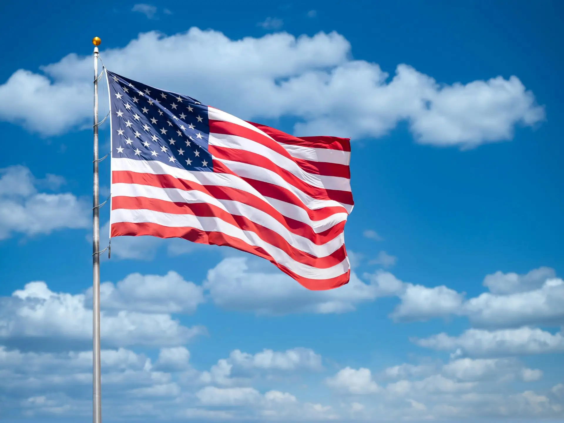 Blauer Himmel mit Wolken und USA-Flagge
