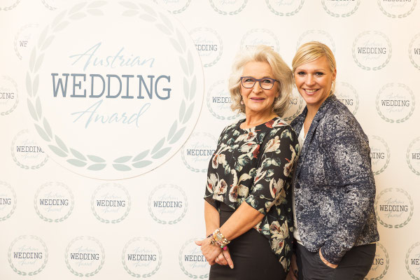 Heike Schönbacher und Gabriele Koch vor Fotowand des Austrian Wedding Award