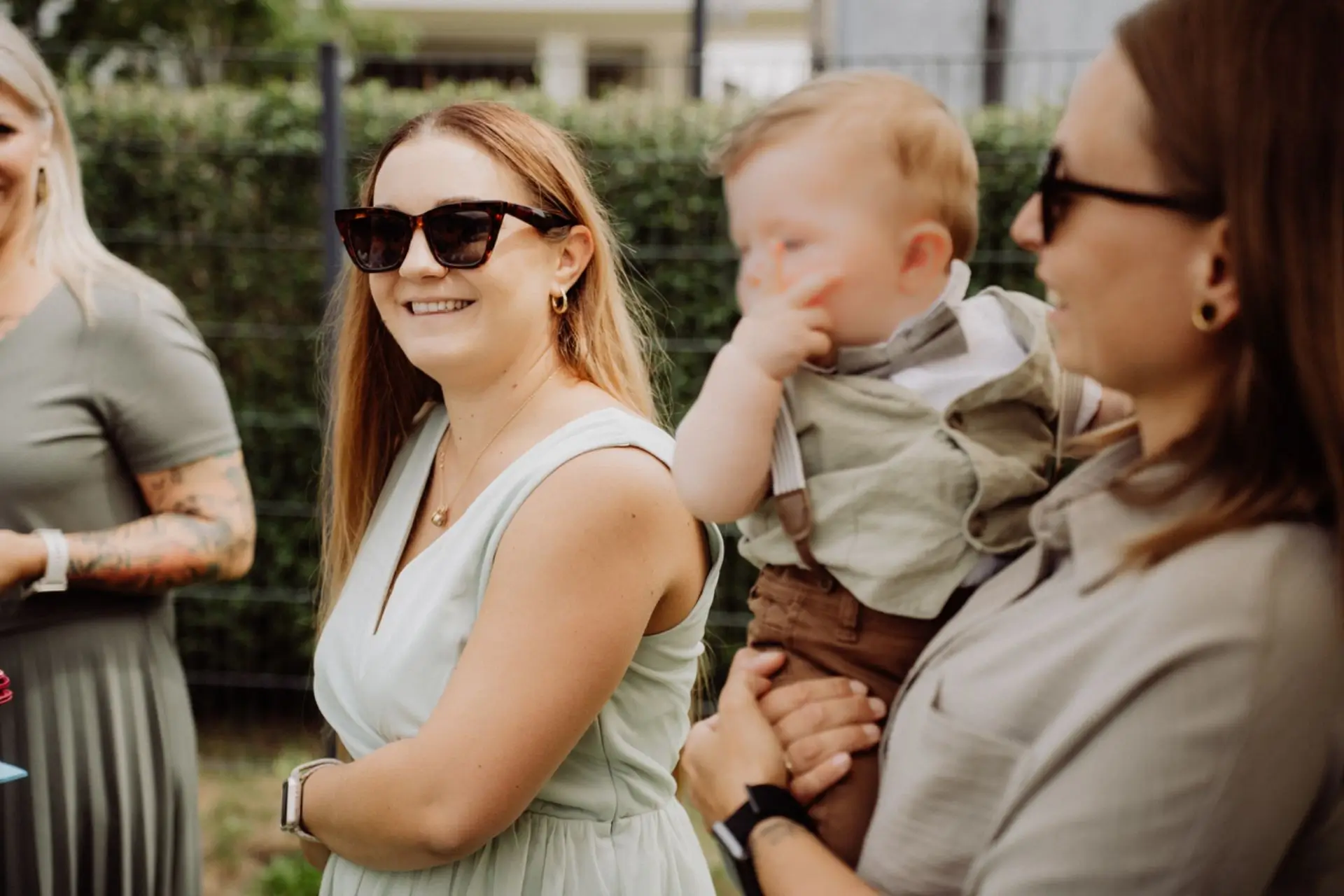 Willkommensfest Sohn Oskar im eigenen Garten Villach, zwei Frauen mit dem Jungen am Arm im Garten