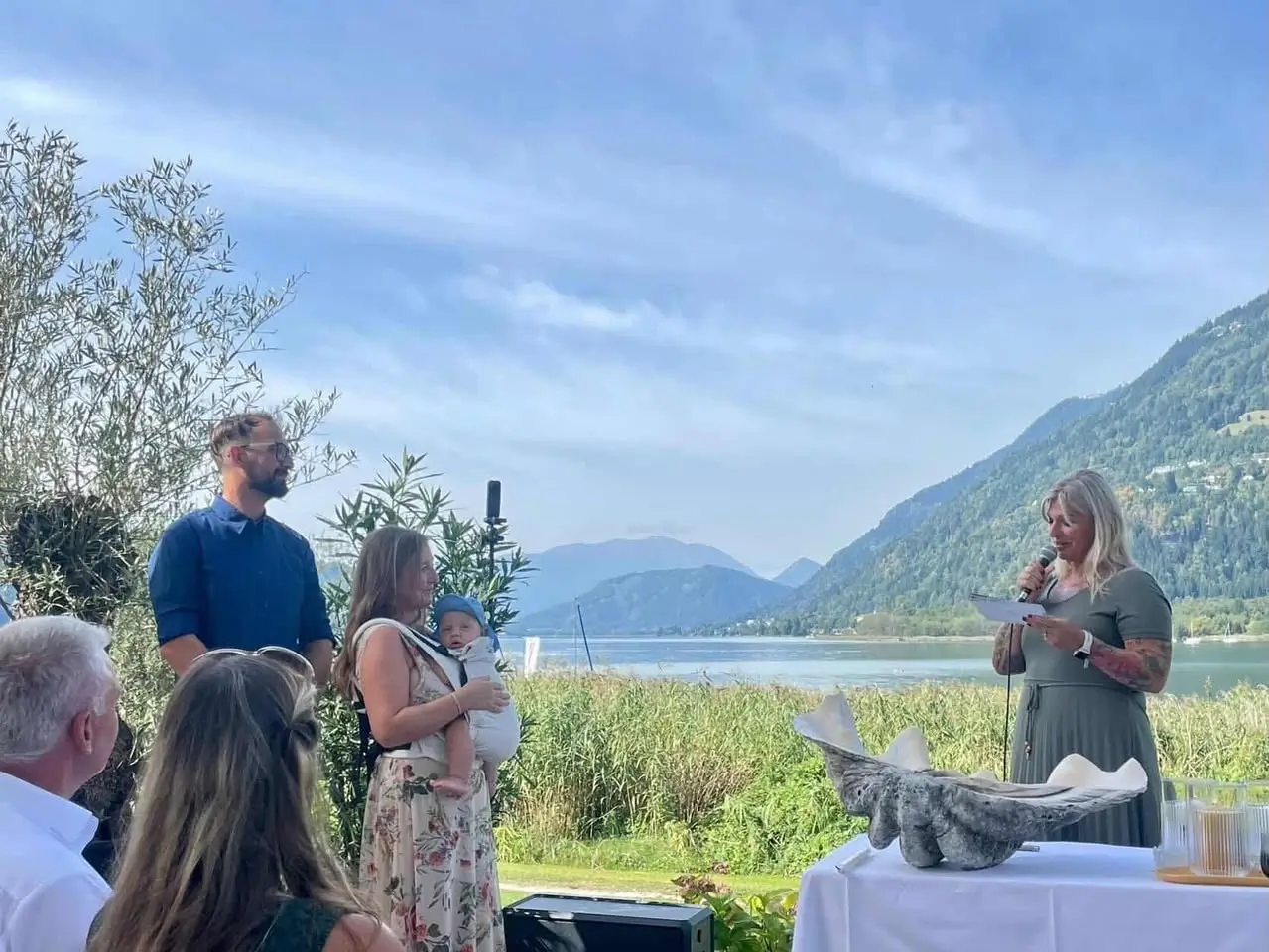 Freie Rede beim Namensfest direkt vor dem Ossiachersee in der Wiese mit Eltern, Baby und Gästen